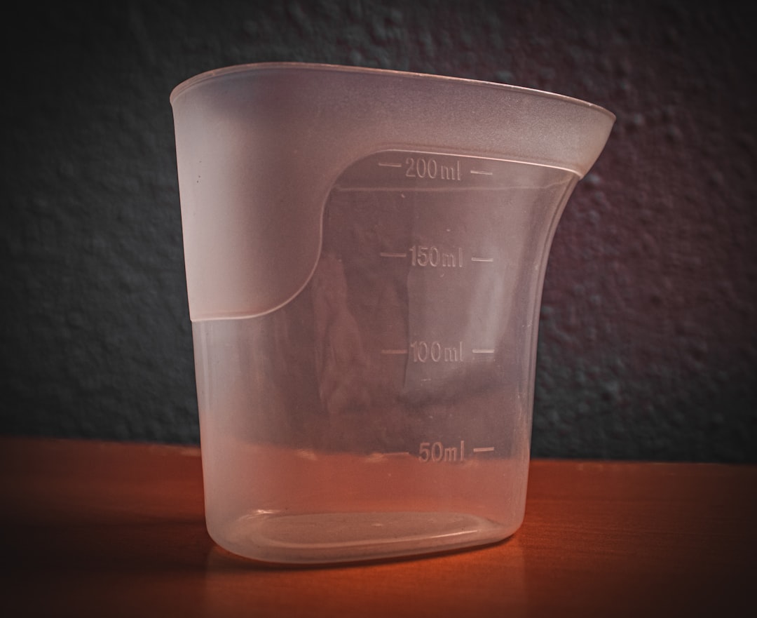 A dog food bag next to a measuring cup showing the 25% rule dog food portion